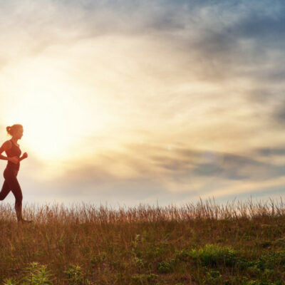 a woman goes for a run through a meadow