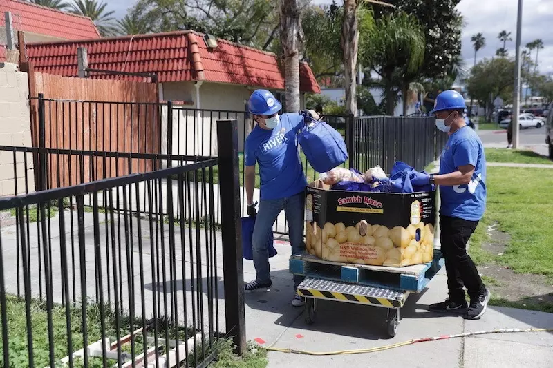 people passing out meal kits in a city during covid-19