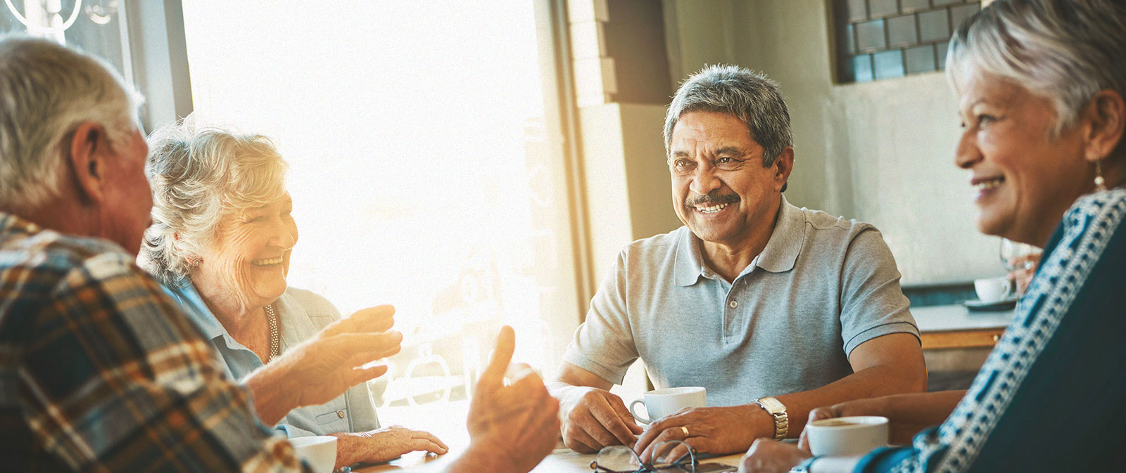 a group of elderly friends sitting at a restaurant discussing business
