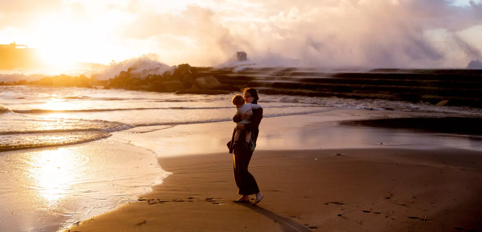 a mom and her son walk on the beach