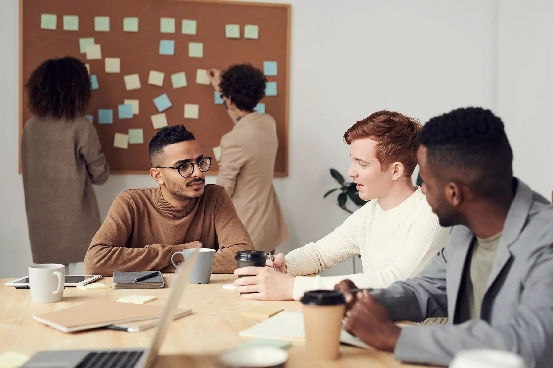 a group of young men sit at a table with their coffee cups and discuss legacy planning