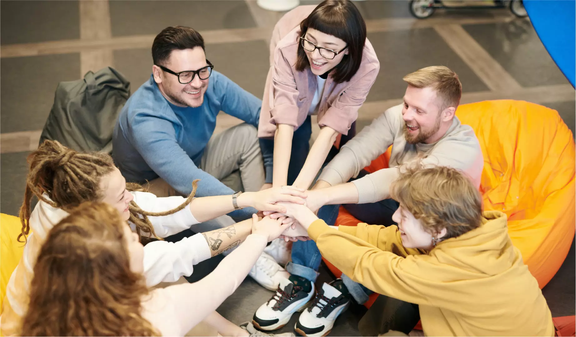 a group of millennials putting their hands in
