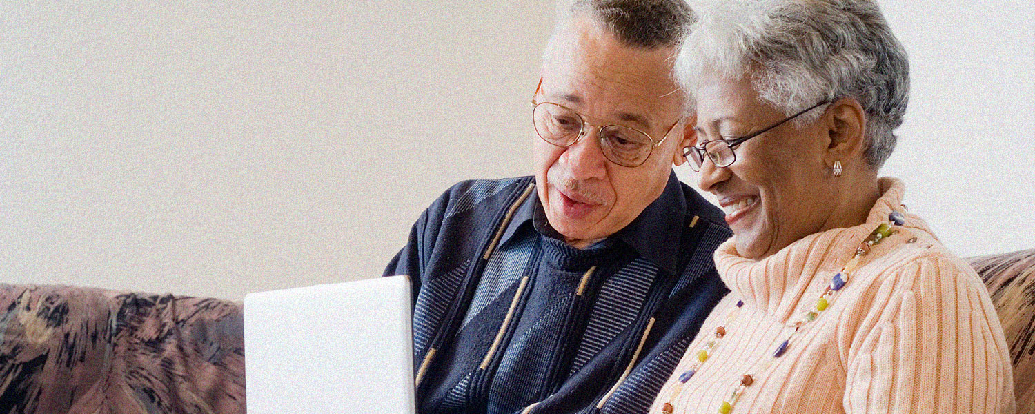 an older couple sits on the couch looking at their computer looking at a donor advised fund