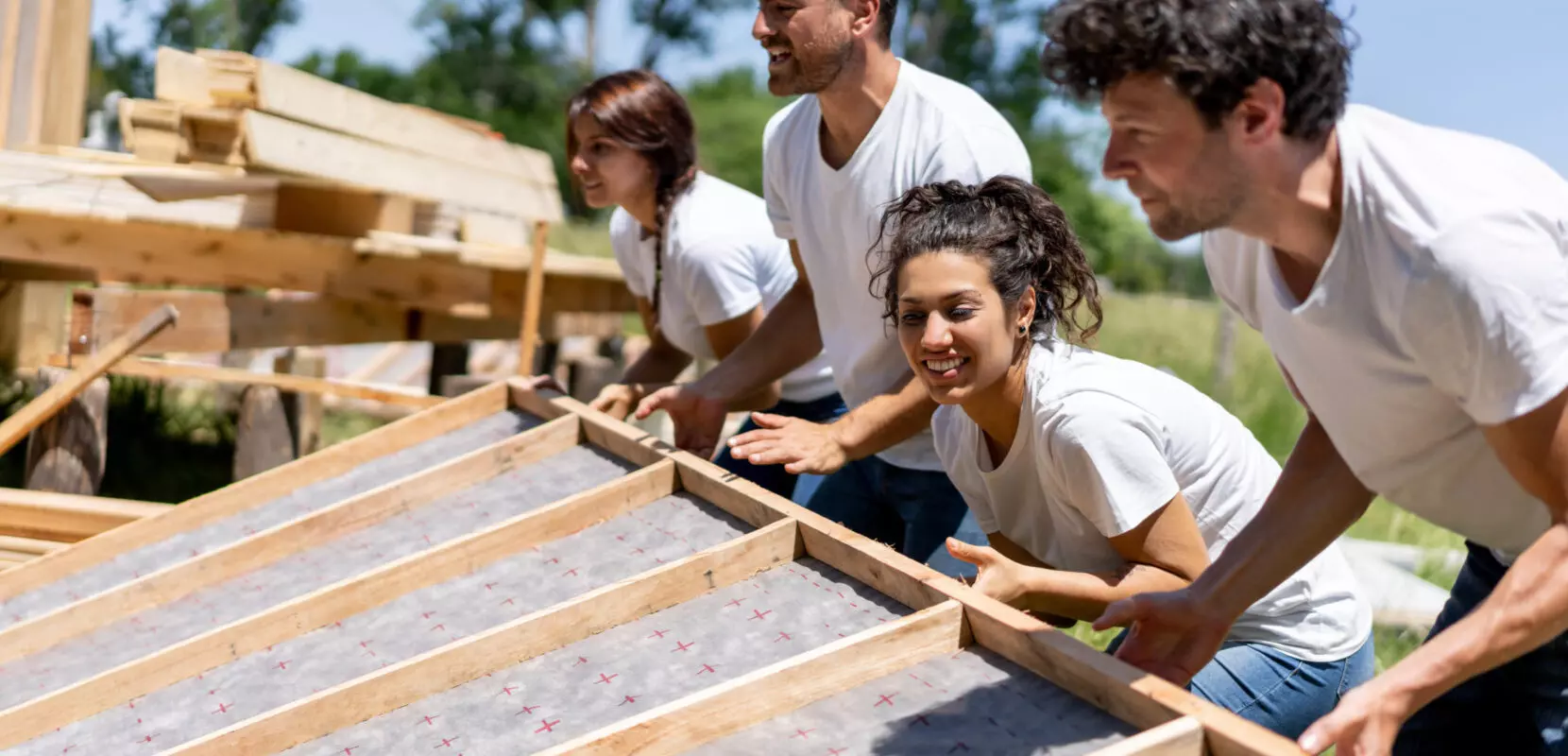 a group of volunteers putting up a wall for a house for charity