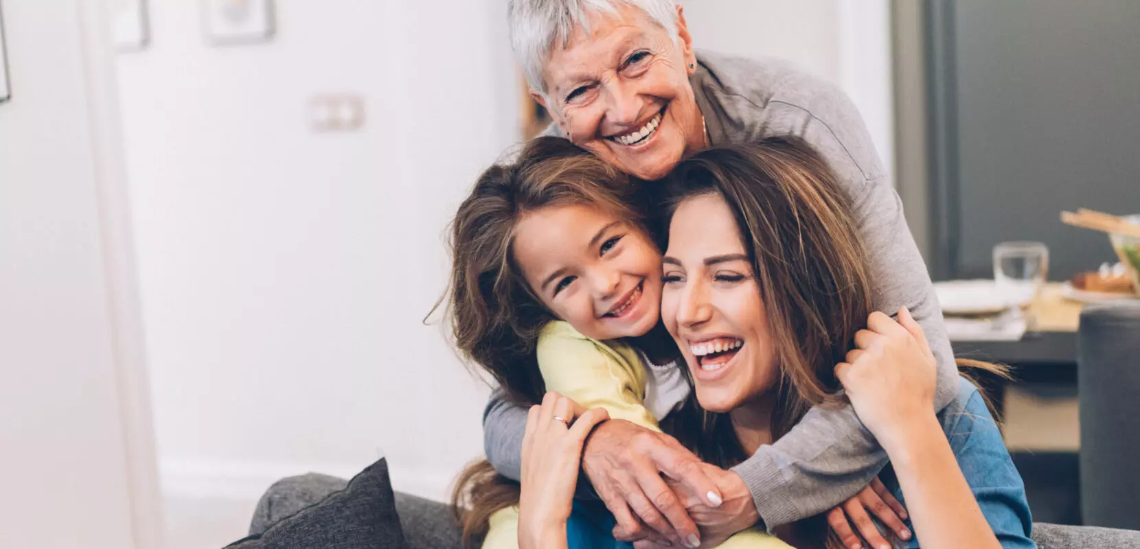 a grandmother, mother, and daughter hugging