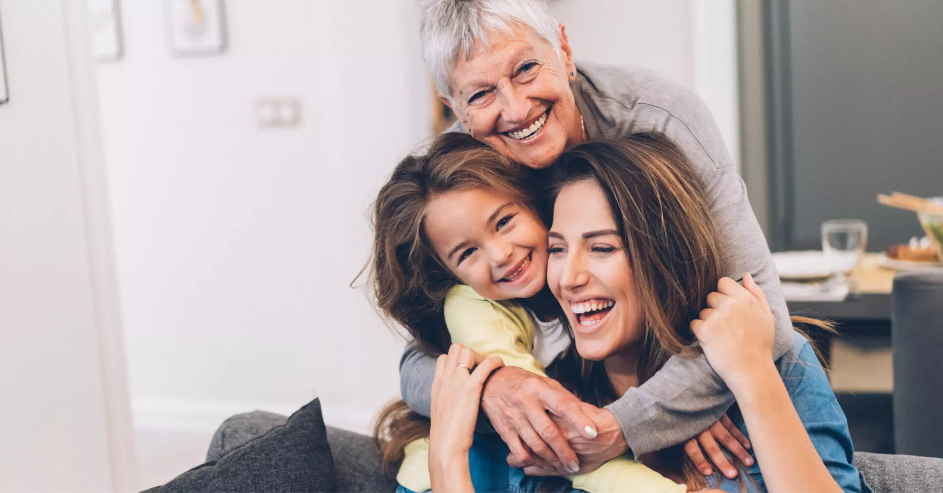 a grandmother, mother, and daughter hugging