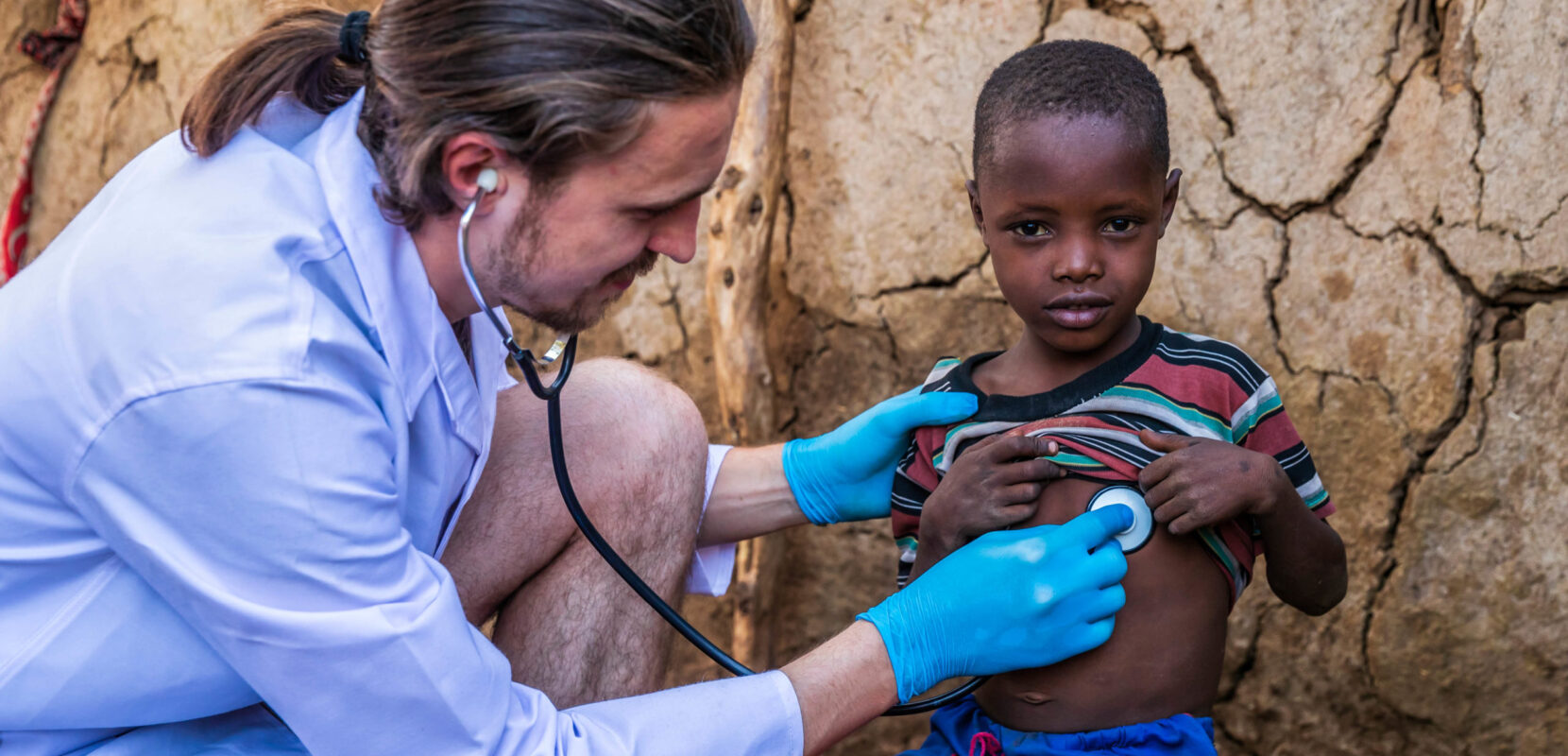 a doctor checking on the health of a child using a stethoscope