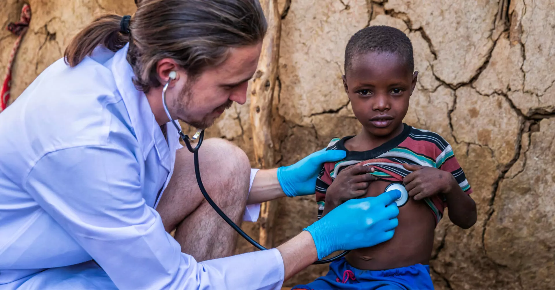 a doctor checking on the health of a child using a stethoscope