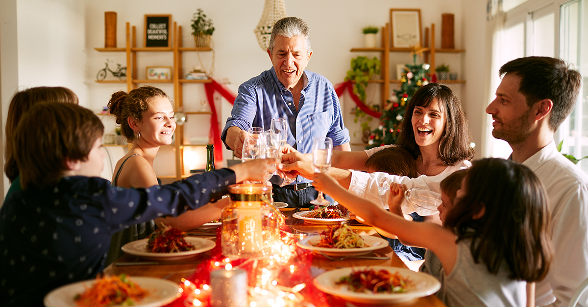 multigenerational family gather around a christmas table and make toasts while conversing about building lasting family values