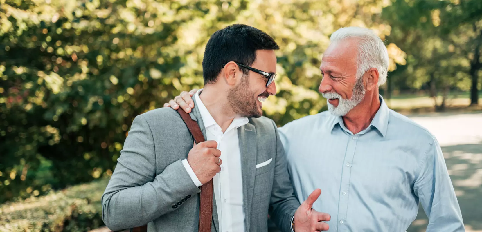 a financial advisor takes a walk through a park with a client to discuss a business sale