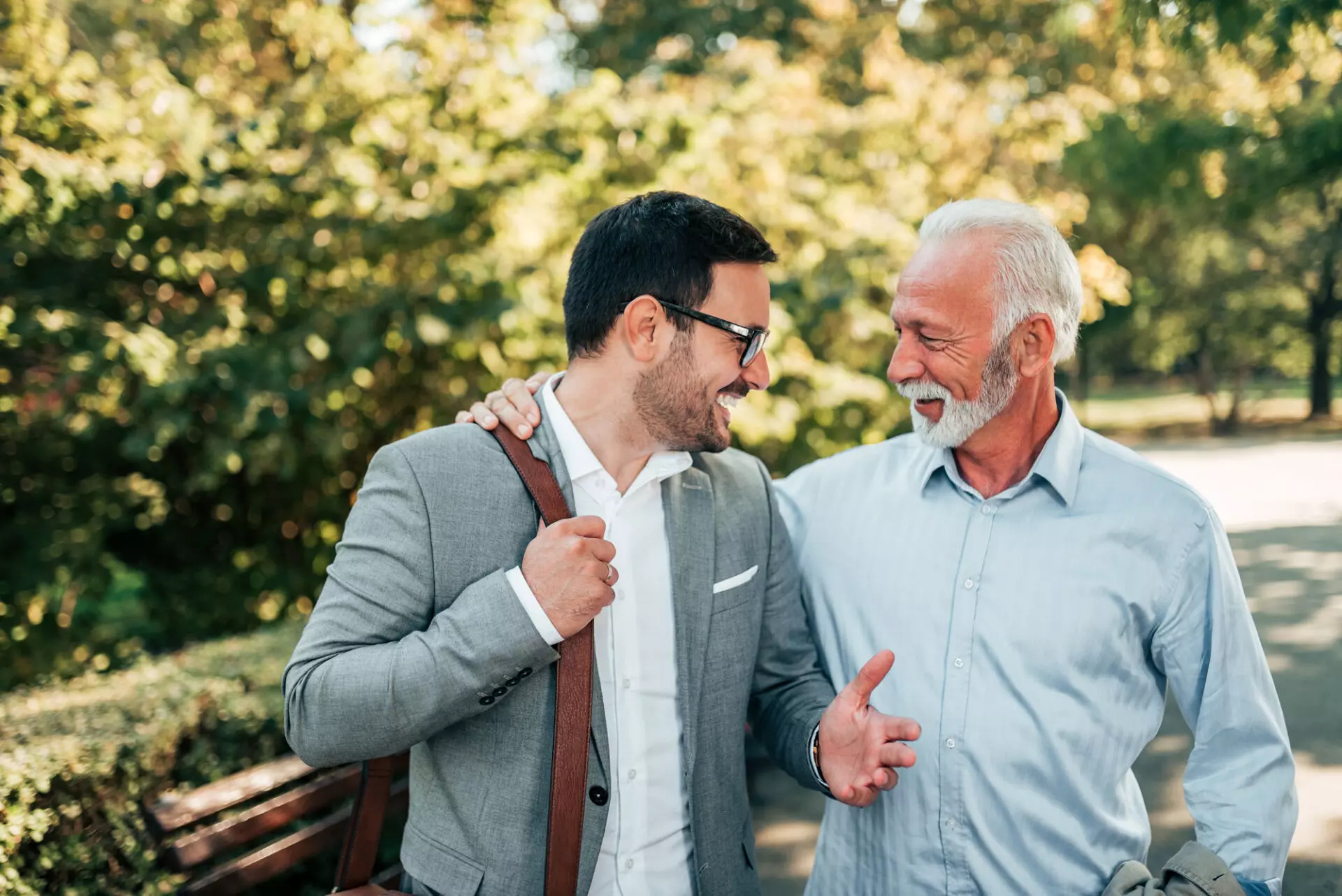a financial advisor takes a walk through a park with a client to discuss a business sale
