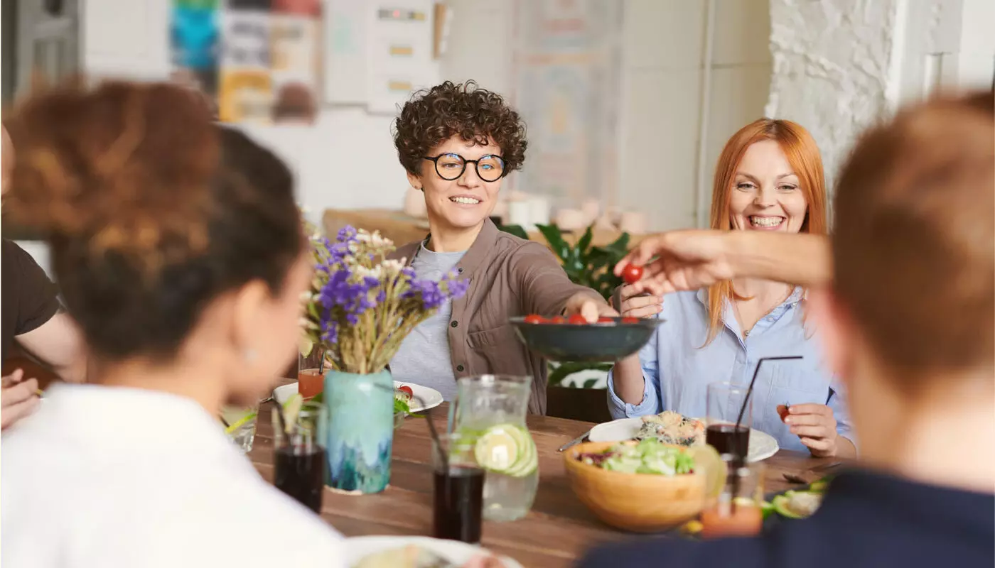 a generous group of friends share a meal together in one of their homes