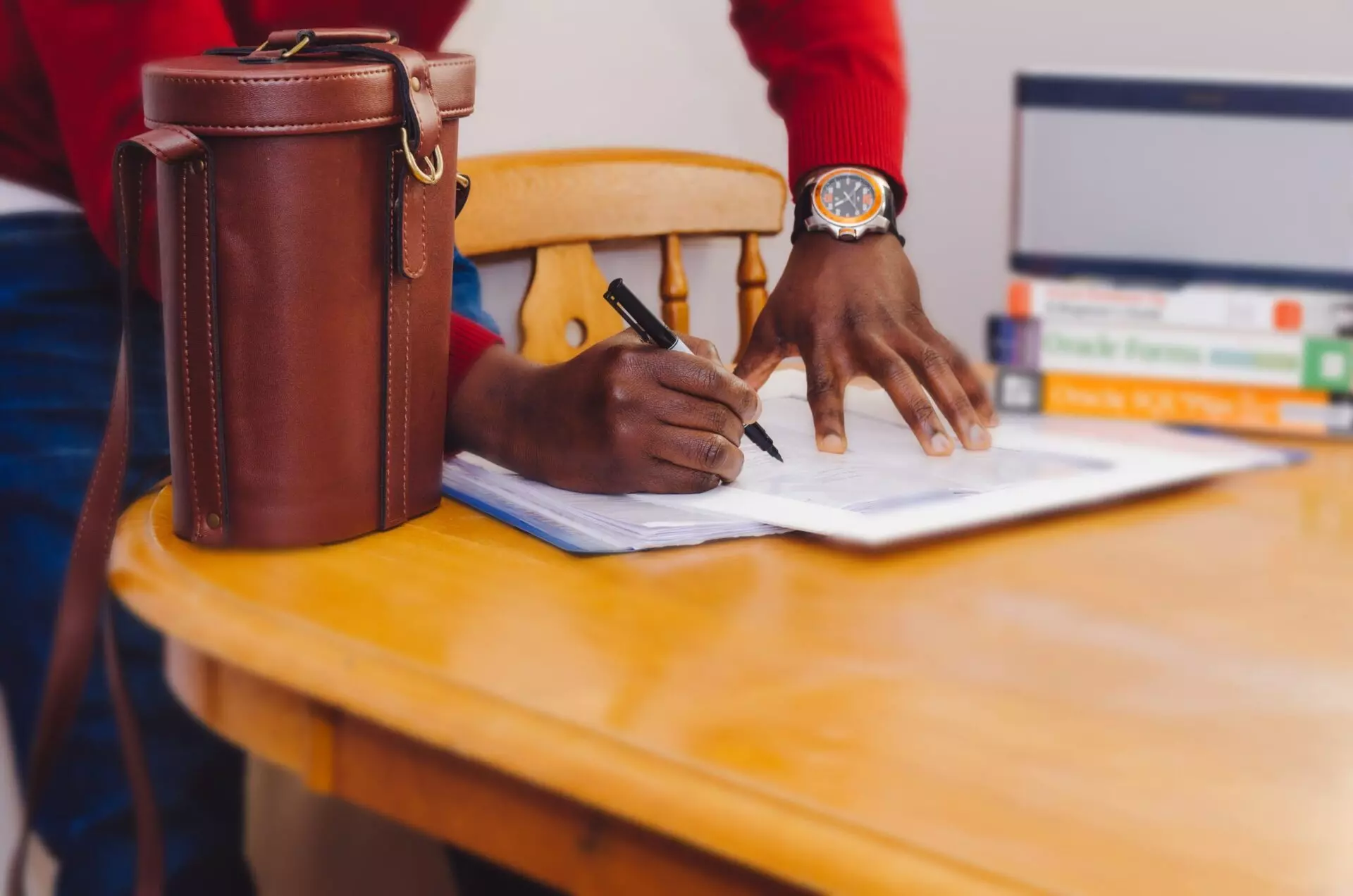 a man fills out paperwork for a business interest gift at a table