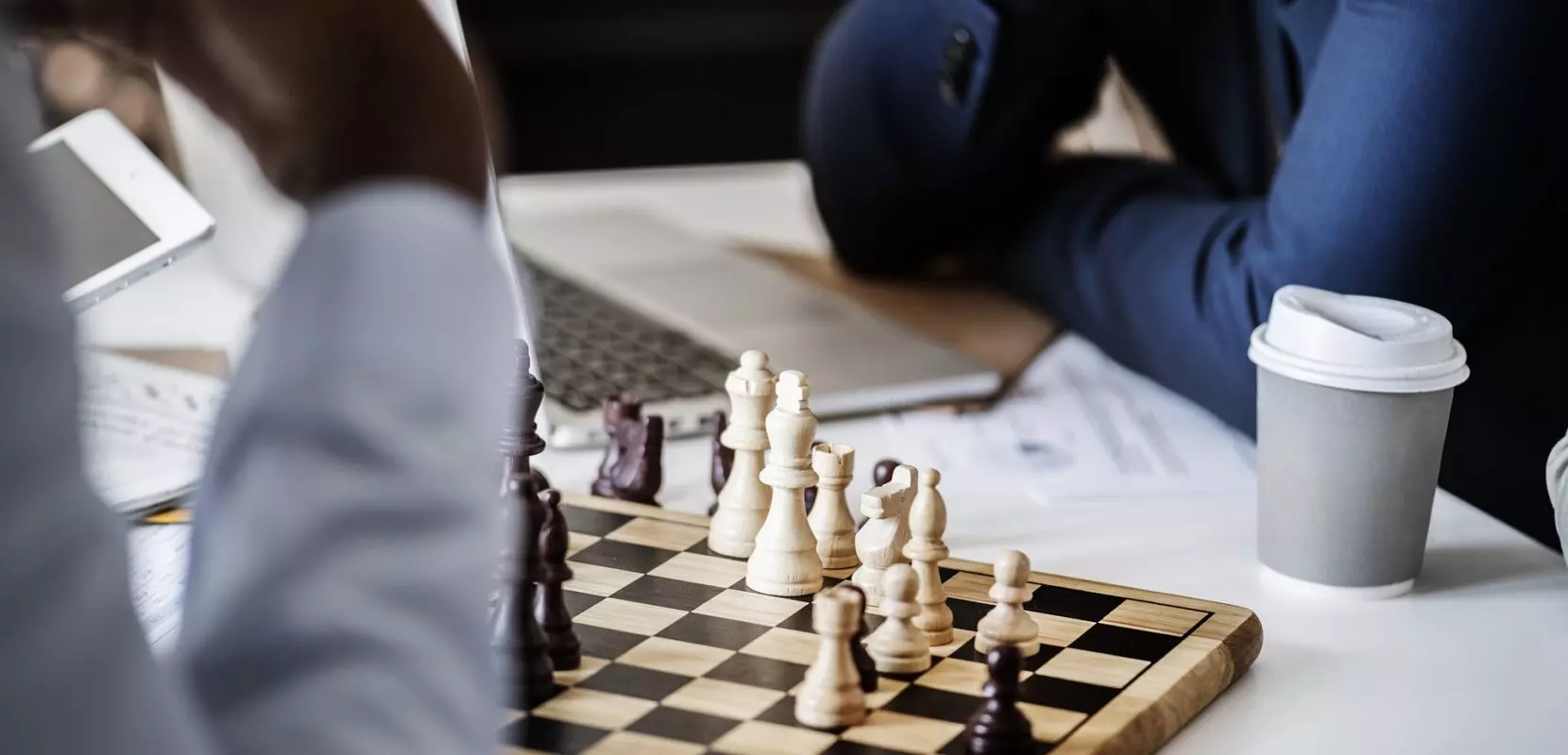 two men sitting at a table playing chess