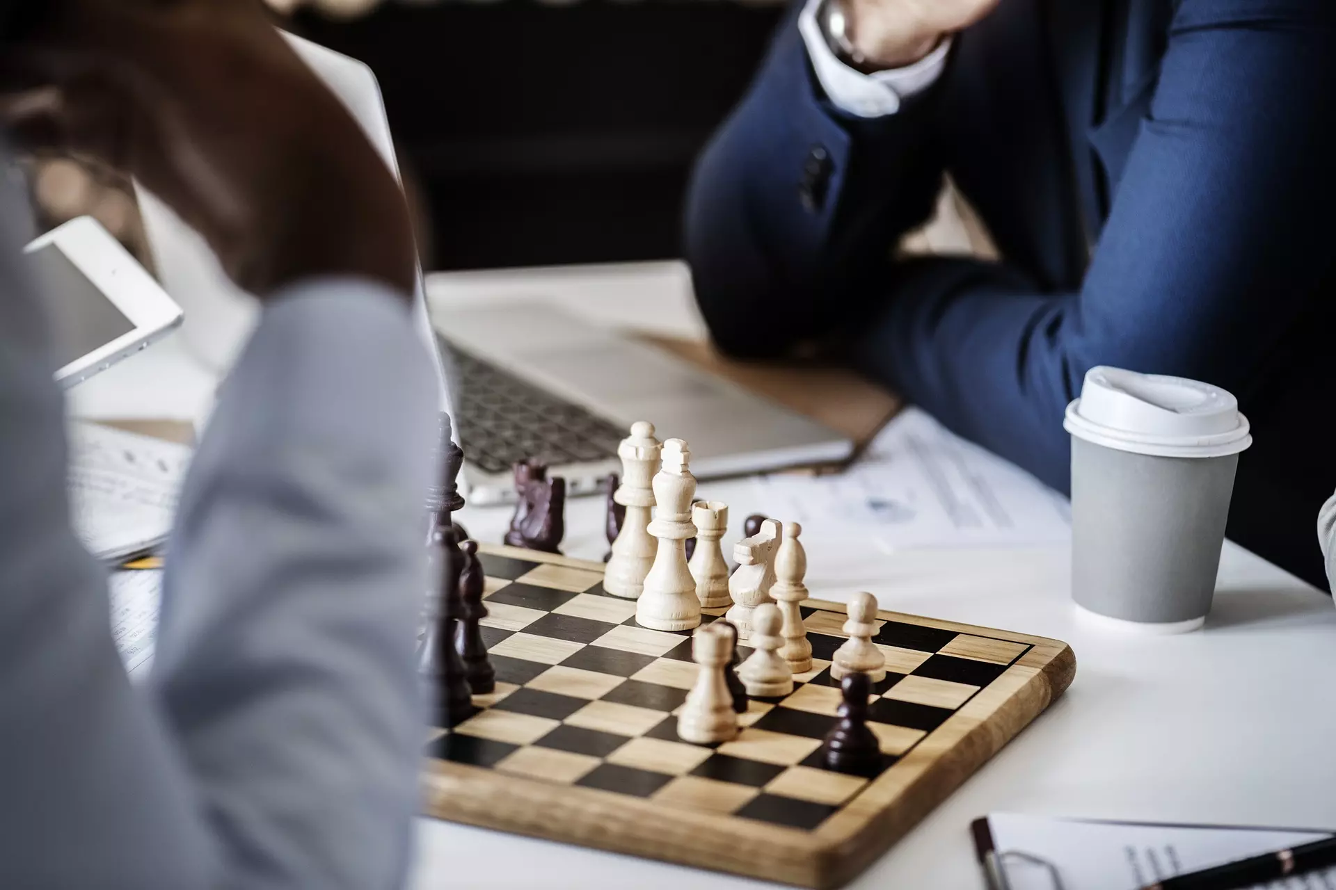two men sitting at a table playing chess