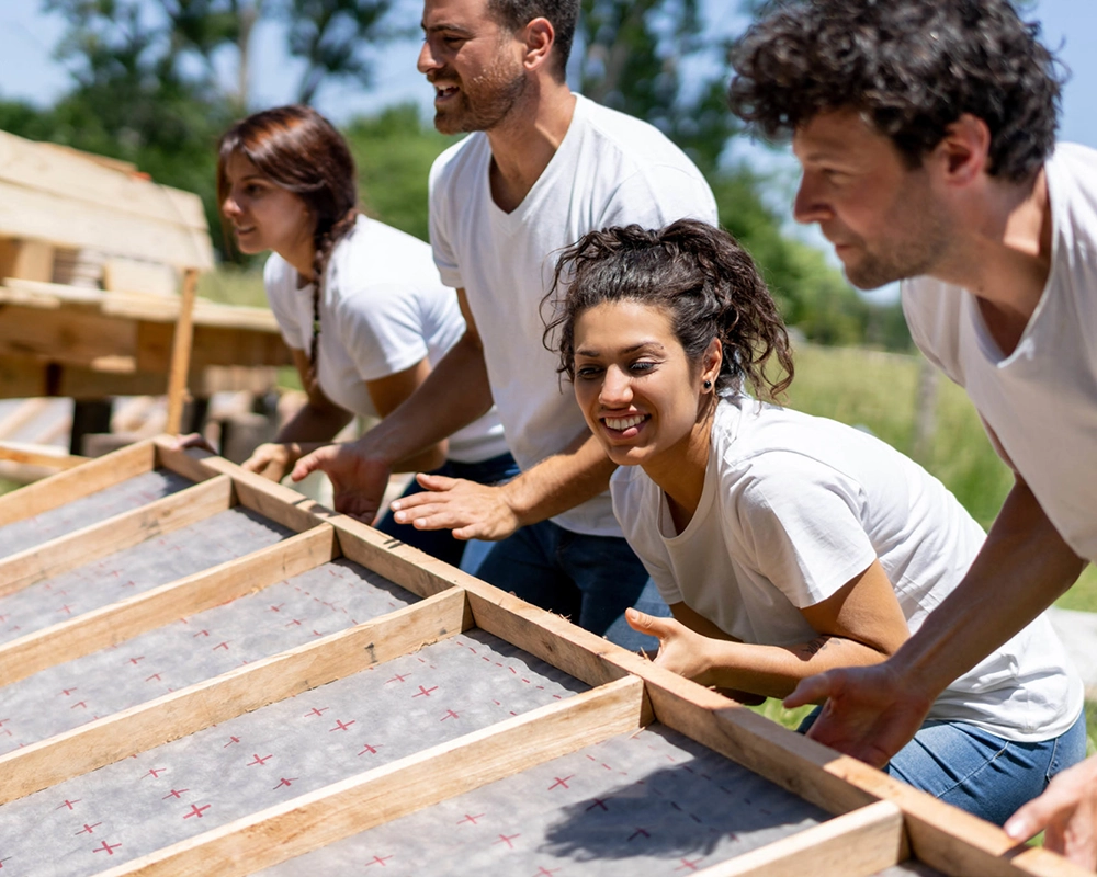 group lifting a wall while building a home for charity