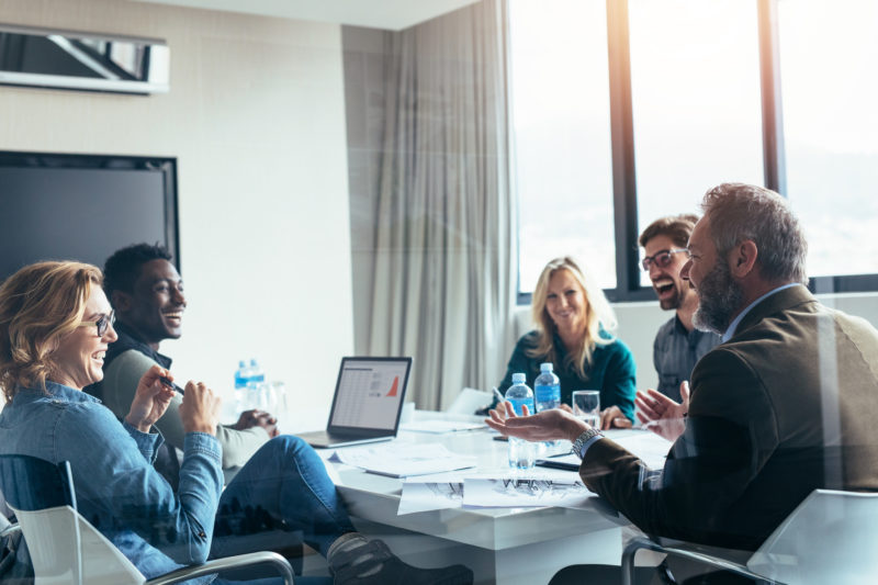 Business people having casual discussion during meeting in board room.