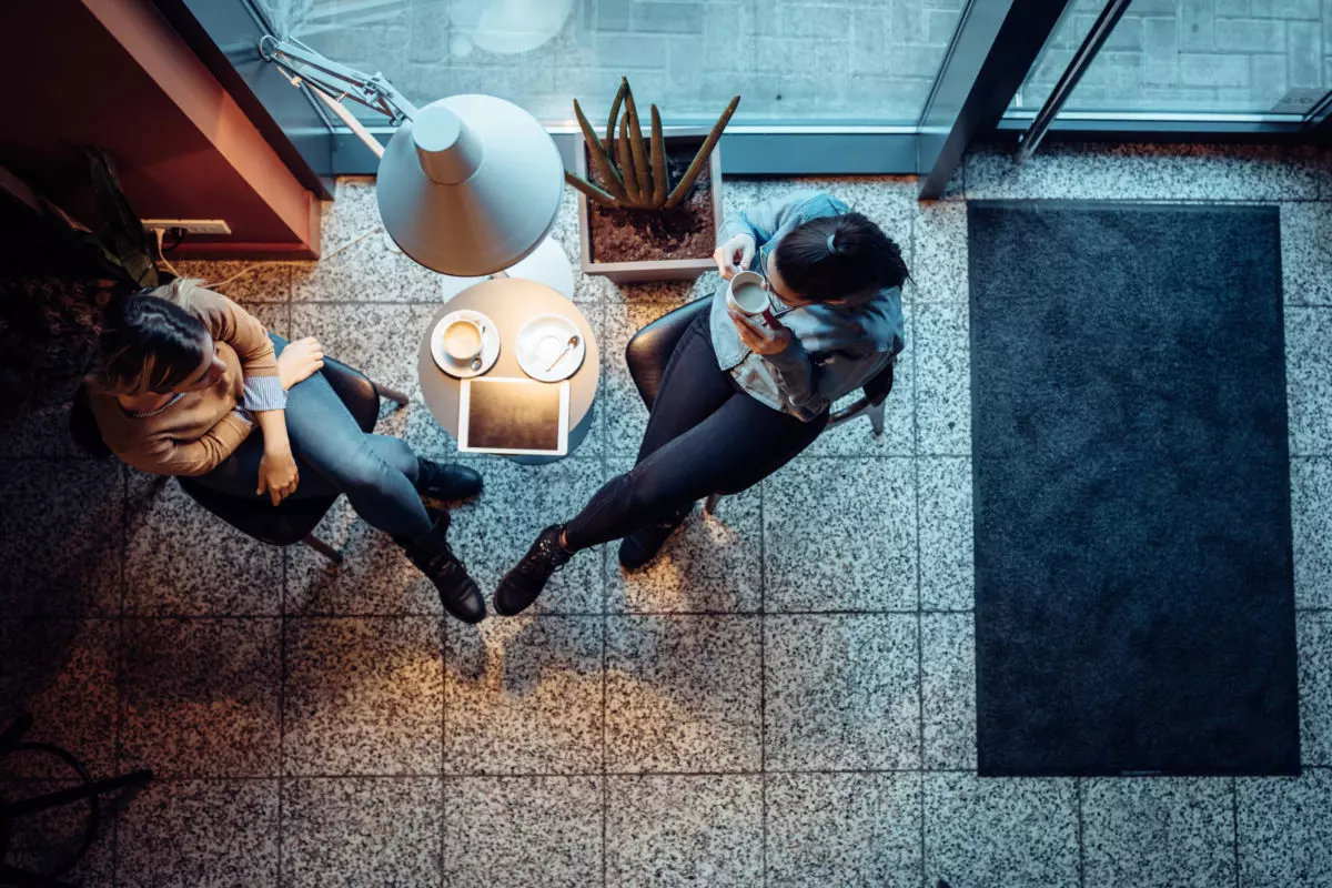 two women sit at a coffee shop