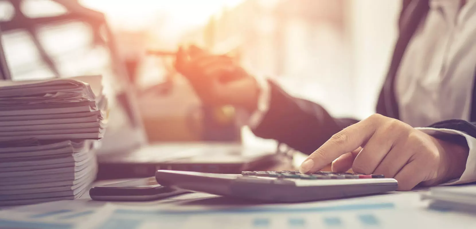 business woman uses calculator and takes notes to evaluate the year