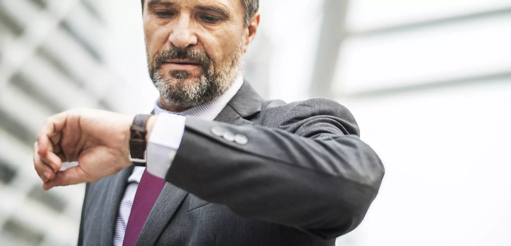 a businessman checking his watch to see if it is time to sell his business