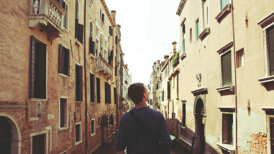 a young man walking through a narrow street